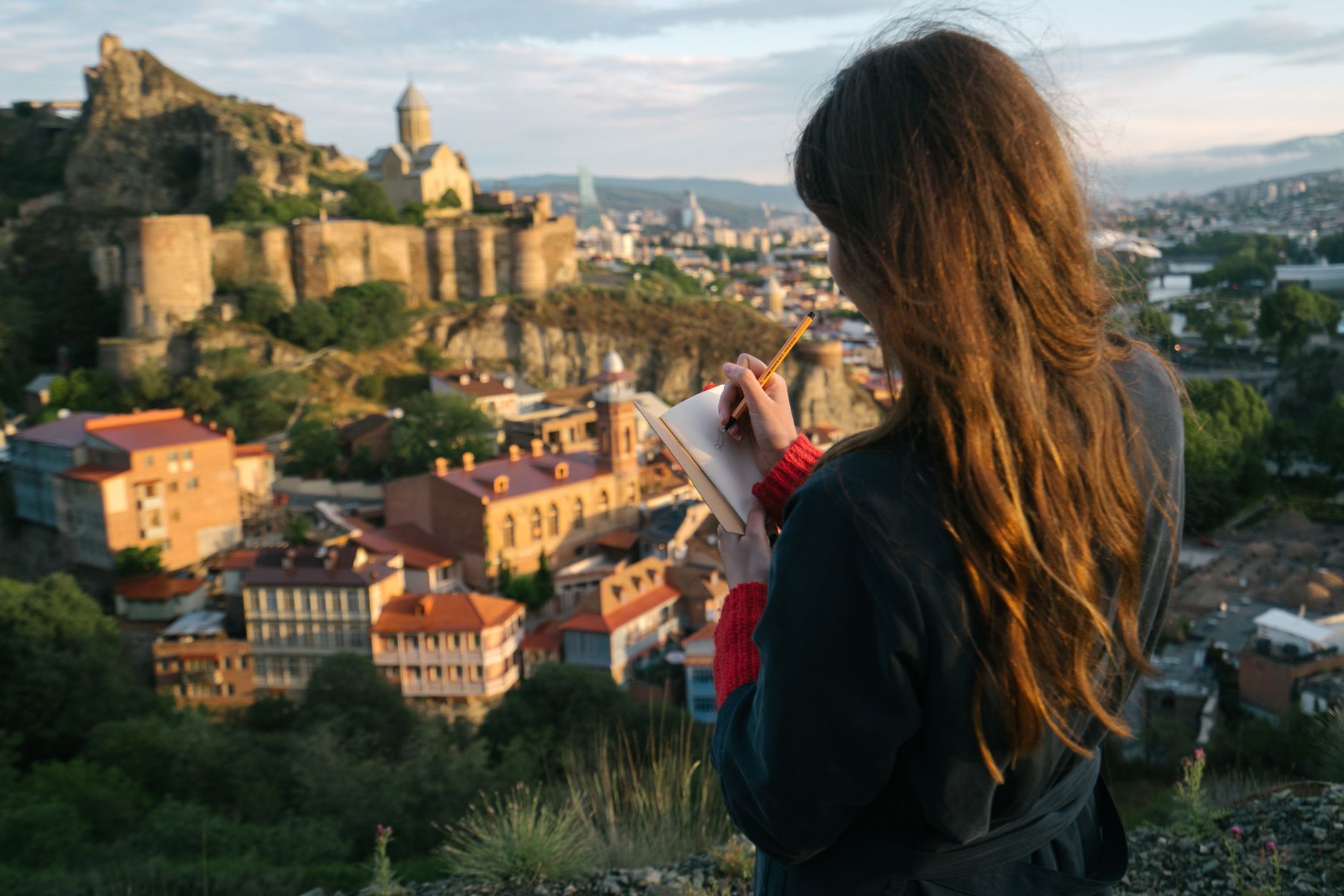 Travel writer documenting landscapes in a journal